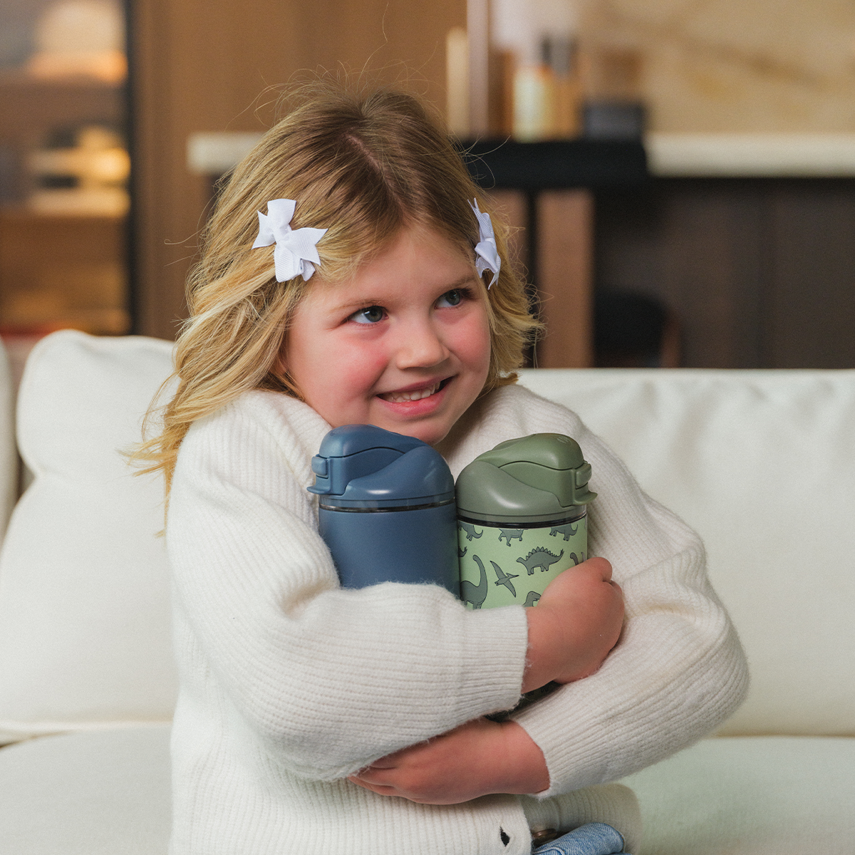 Girl Holding 14oz Cascade and Dinosaur HydroJug Ease2o